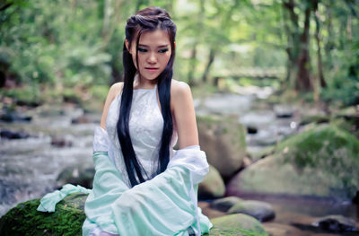 Young woman standing against tree