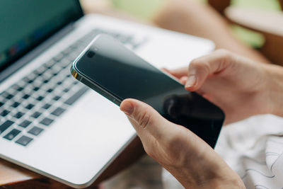 Cropped hand of man using laptop