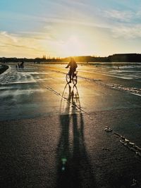 Silhouette of woman against sunset sky