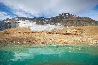 Scenic view of sea and snowcapped mountains against sky