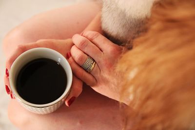 Midsection of woman holding coffee cup