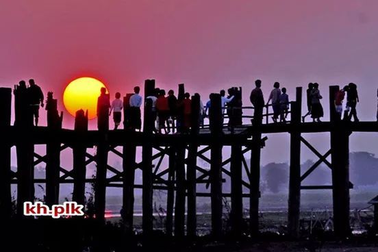 architecture, sunset, built structure, sky, railing, silhouette, clear sky, building exterior, men, city, sea, orange color, water, large group of people, outdoors, copy space, bridge - man made structure, fence, dusk