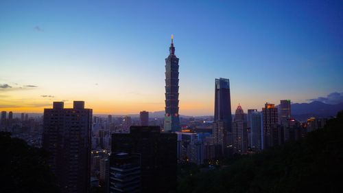 Skyscrapers in city at sunset