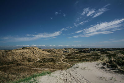 Scenic view of sand dunes against sky