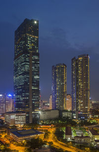 Illuminated buildings in city against sky at night