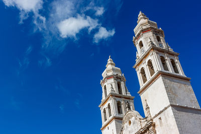 Low angle view of bell tower against blue sky