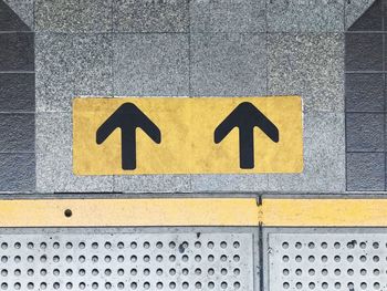 Close-up of arrow sign on wall