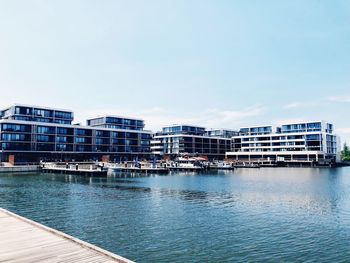 Buildings by sea against clear sky