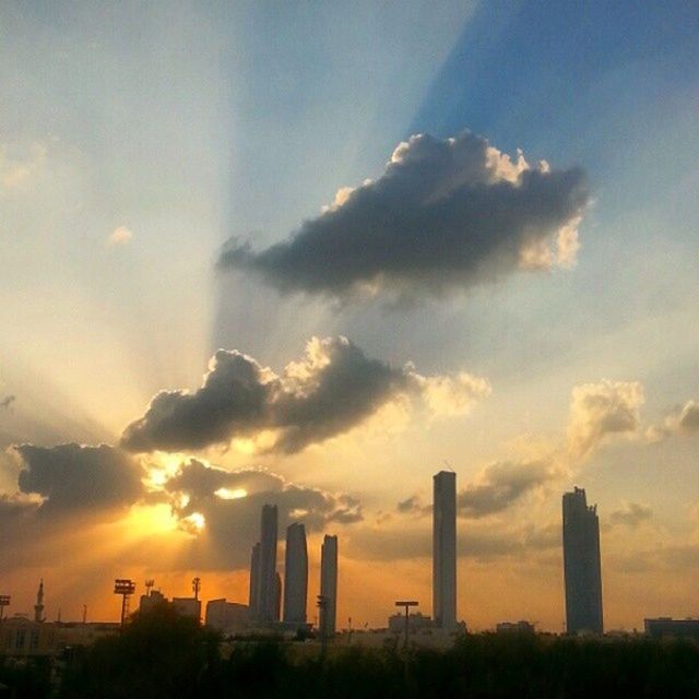 architecture, building exterior, built structure, sunset, city, sky, skyscraper, sun, cloud - sky, sunbeam, tall - high, sunlight, urban skyline, silhouette, tower, cityscape, modern, cloud, orange color, outdoors