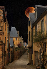 Alley amidst buildings in city at night