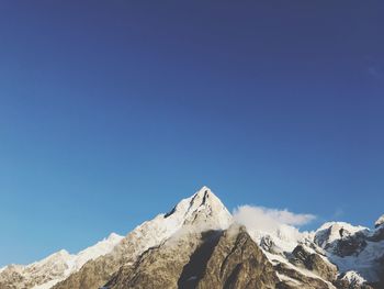 Low angle view of mountains against clear blue sky