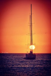 Sailboat sailing on sea against sky during sunset