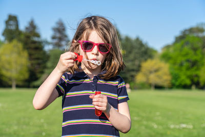 Portrait of boy wearing sunglasses standing on field