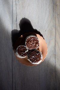 Directly above shot of hand holding ice cream on table