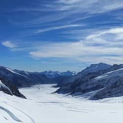 Scenic view of snow covered mountains against sky