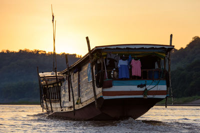 Boats in calm sea at sunset