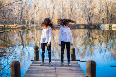 Rear view of women standing against trees