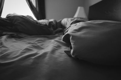 Low section of man relaxing on bed