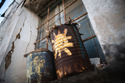 Closeup of old metal cans used as plant vase on abandoned home window