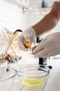 Midsection of person pouring drink in glass on table