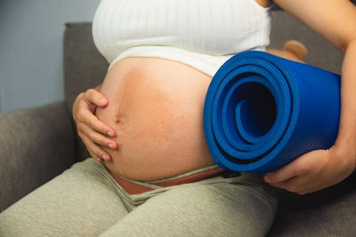 Midsection of woman holding baby while sitting at home