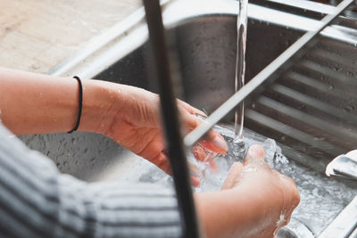 Cropped hands washing dishes