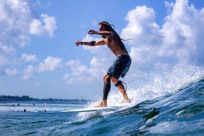 Man surfing in sea against sky
