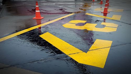 Road markings and traffic cones on wet road