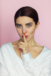 Portrait of beautiful woman against pink background