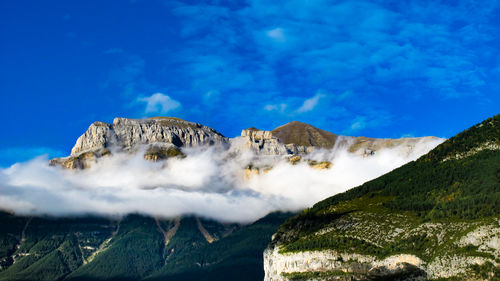 Low angle view of mountain against blue sky