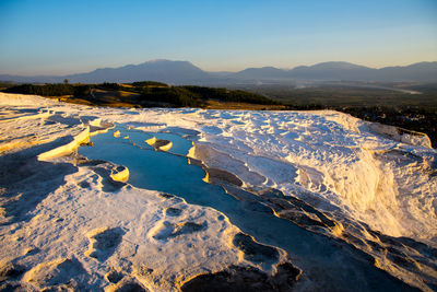 Scenic view of frozen lake against sky during sunset