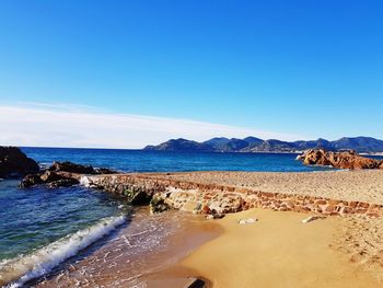 Scenic view of beach against blue sky