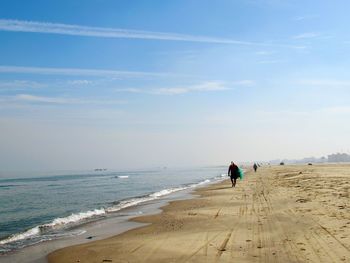 People on beach against sky