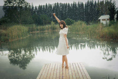 Rear view of woman standing against lake