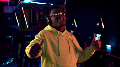 Portrait of young man standing in internet cafe