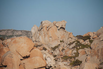 Rock formations on landscape against clear blue sky