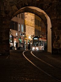 Illuminated street amidst buildings in city at night