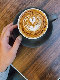 Midsection of woman holding coffee cup on table