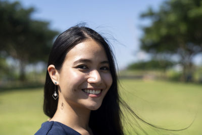 Close-up portrait of smiling beautiful woman in park