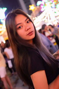 Portrait of beautiful woman standing at night