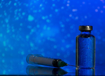 Close-up of bottle on table against blue background