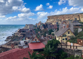 High angle view of townscape by sea against sky