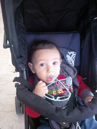 Portrait of cute boy sitting in park