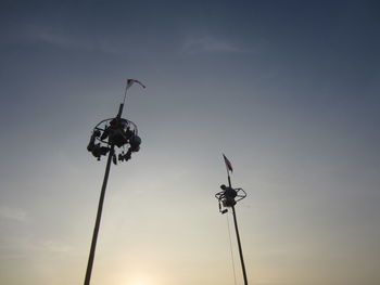 Low angle view of silhouette telephone pole against sky during sunset