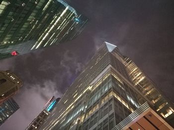 Low angle view of illuminated cityscape against sky at night