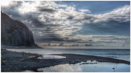 Scenic view of sea against cloudy sky