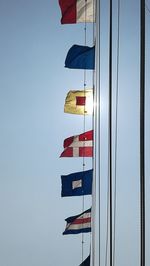 Low angle view of flag against clear blue sky