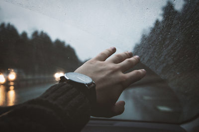 Close-up of man hand on glass window