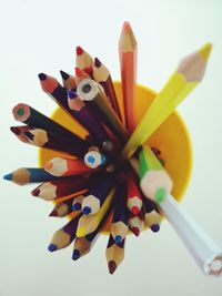 High angle view of multi colored pencils on white background