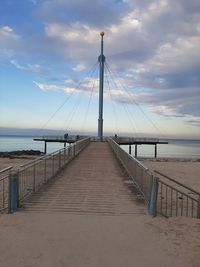 Bridge over calm sea against sky